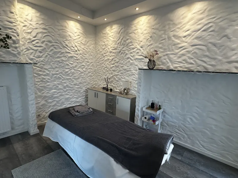 Behandlungsraum mit warmem Licht und strukturierter weißer Wand